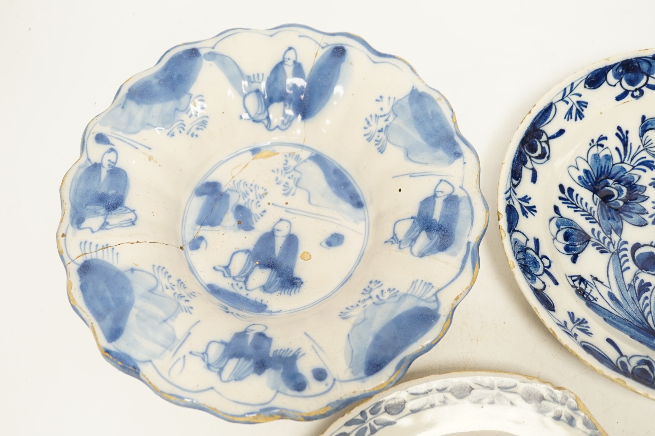 A Delft lobed blue and white dish, 1680-1700 and two 18th century Delft plates, largest 21cm in diameter